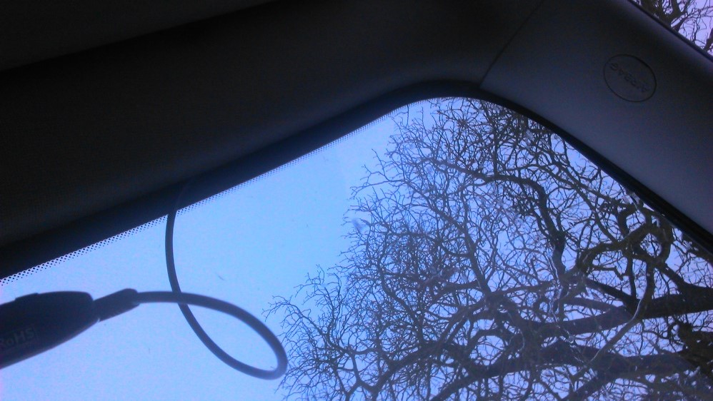 Kabel tažen od kamery škvírou mezi oknem a tapicírunkem střechy směrem k pravému A sloupku